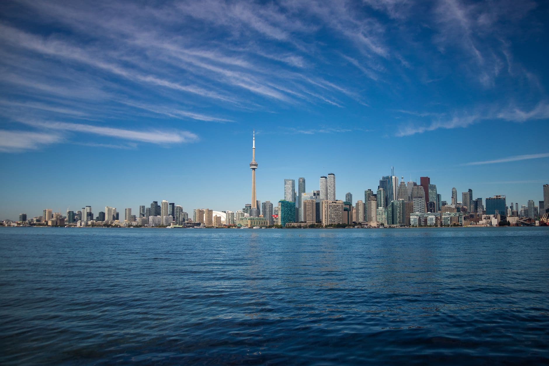 The Toronto skyline and waterfront under a clear sky.