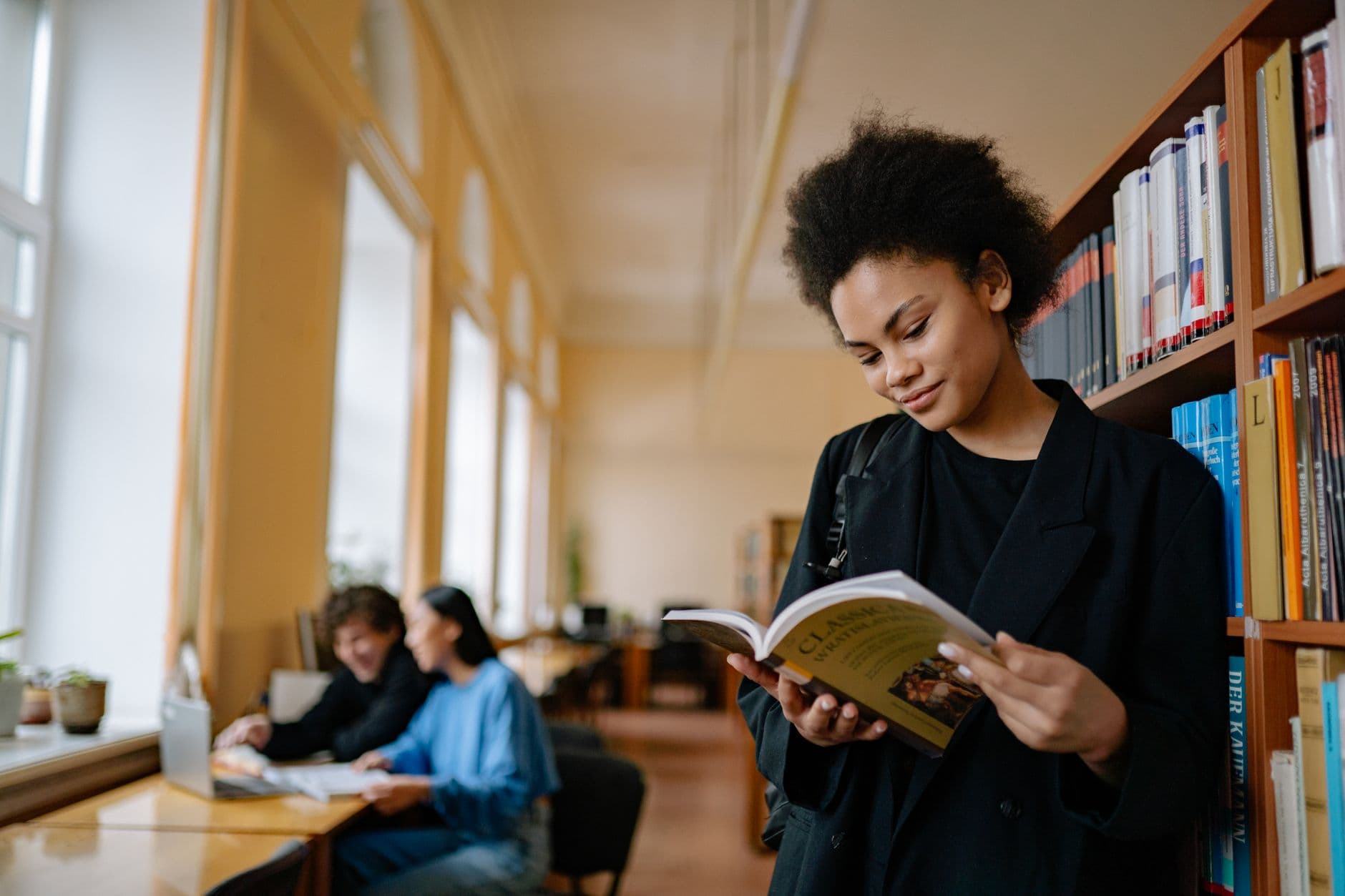 A young woman reading in a quiet library.
