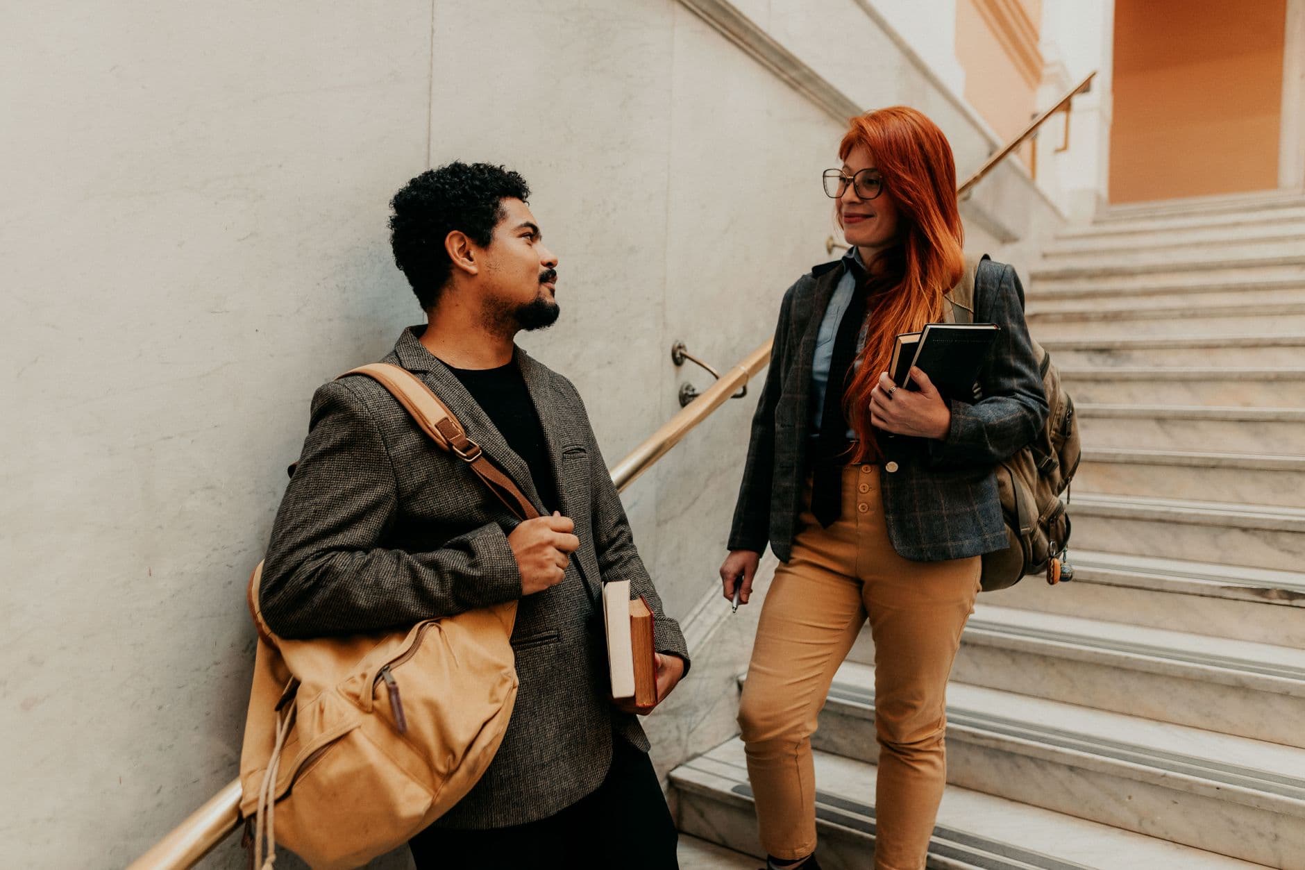 Students talking together on a staircase in a university building.