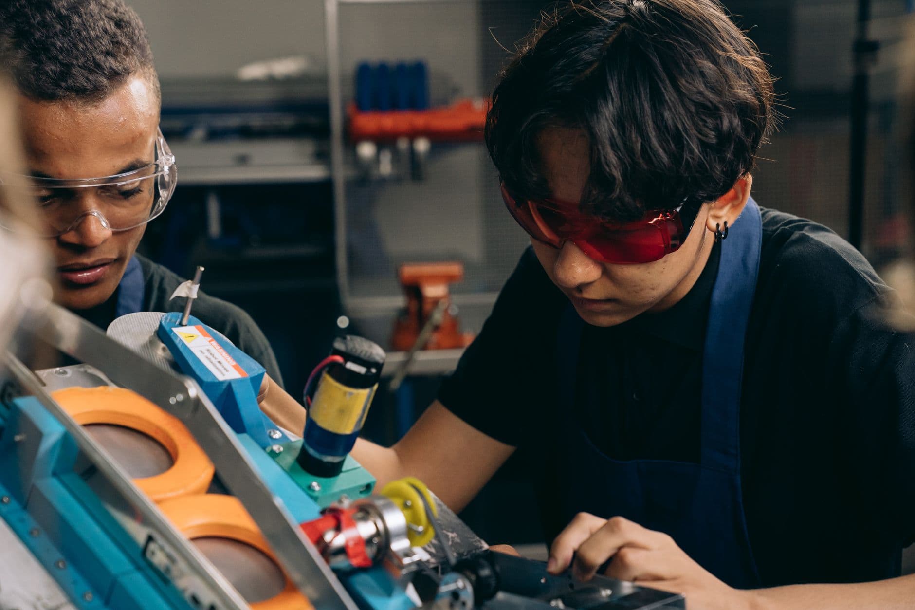 Two engineers doing precision work at a bench in a workshop.