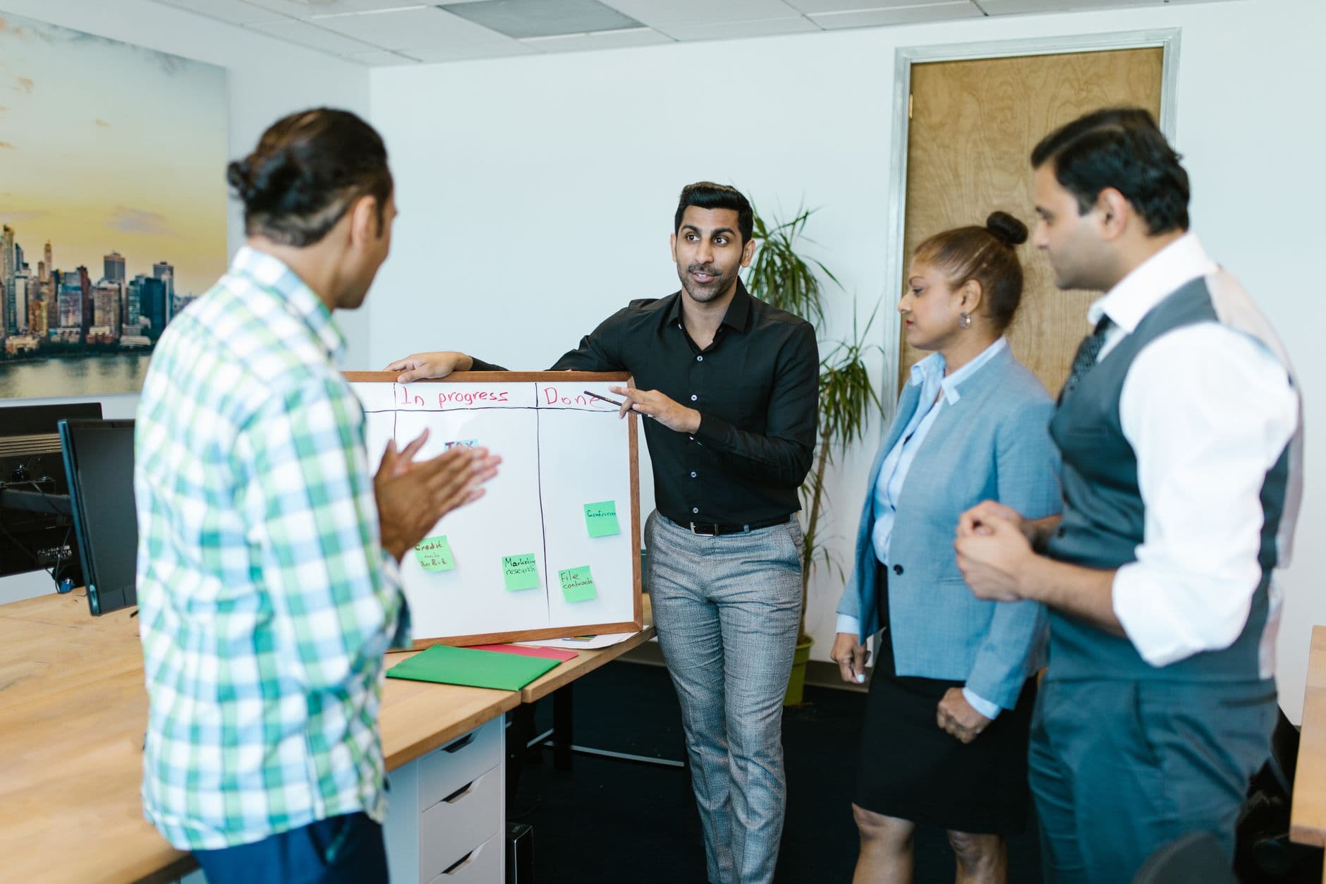 A team discussing progress against a board in an office.