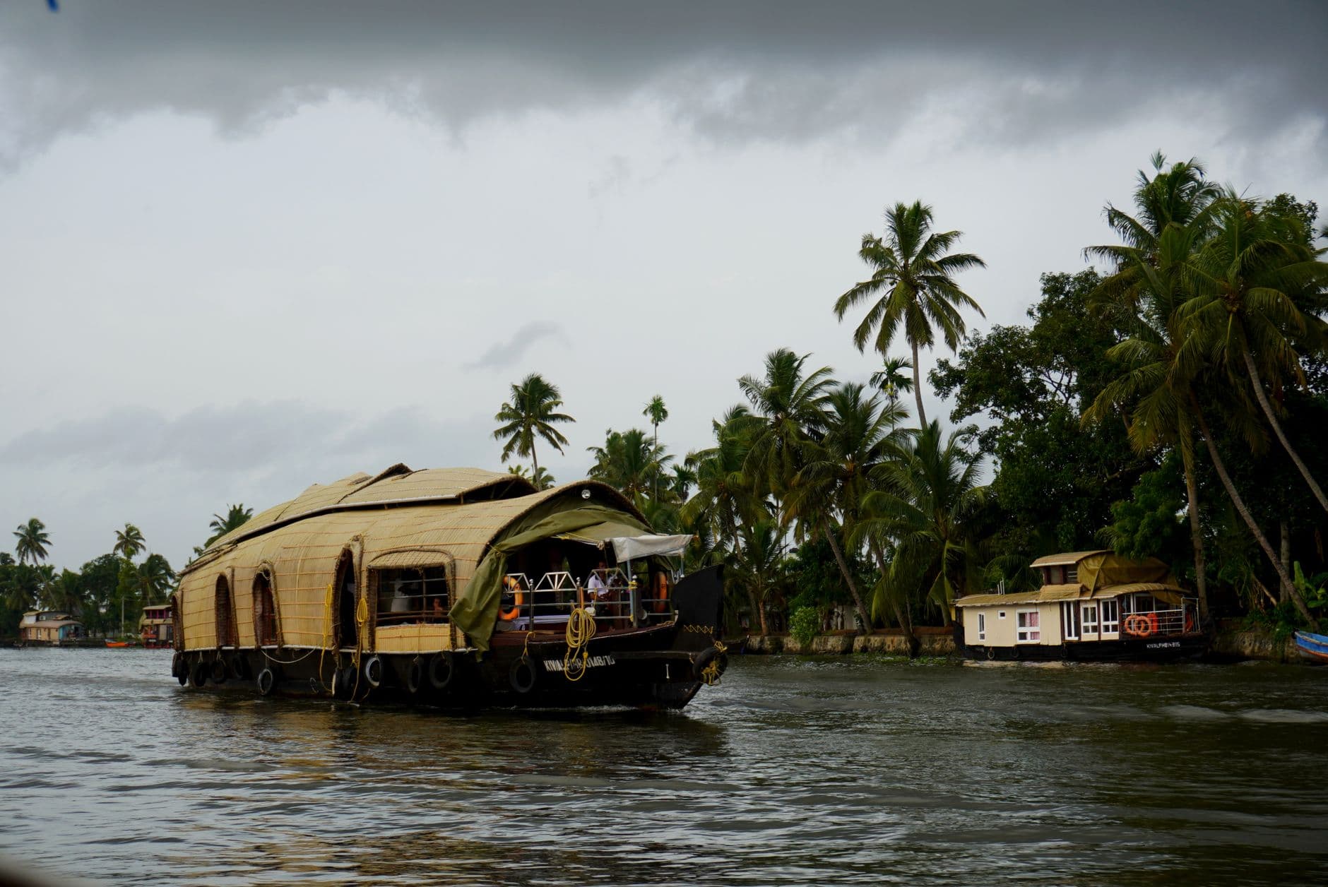 Scenic view of a traditional Kerala houseboat cruising through lush backwaters.