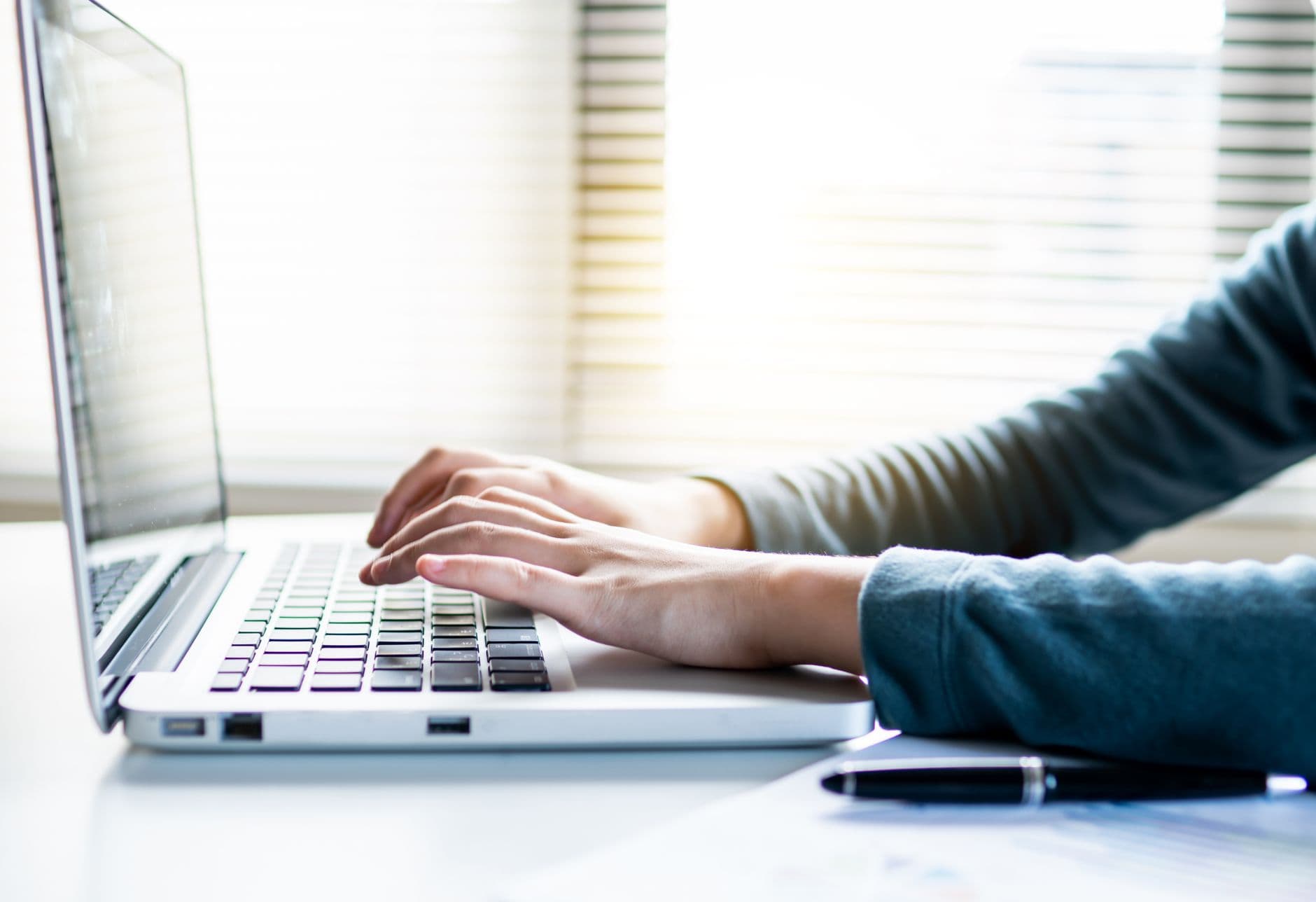 Close-up shot of hands typing on a laptop keyboard, perfect for business or technology themes.