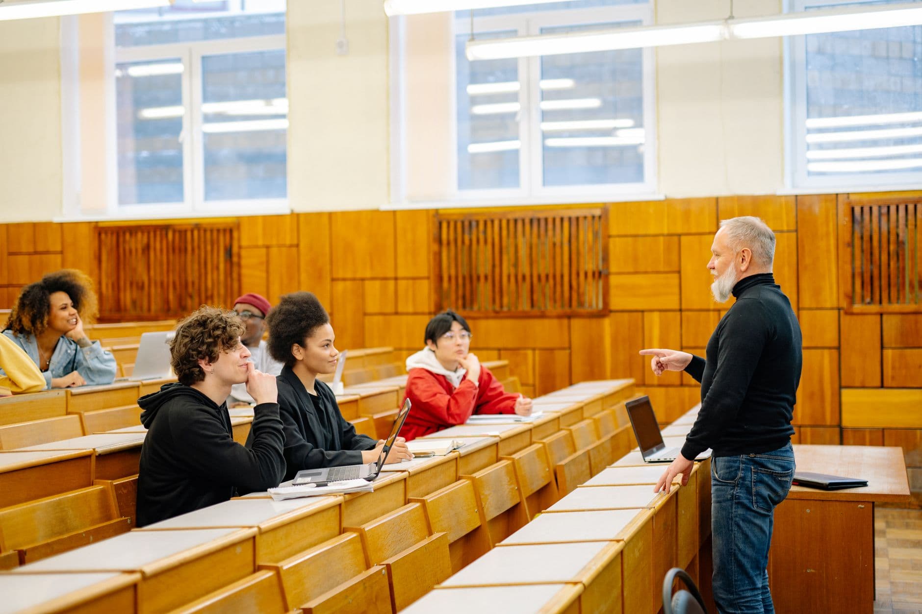A lecturer with a group of students in a university lecture hall.