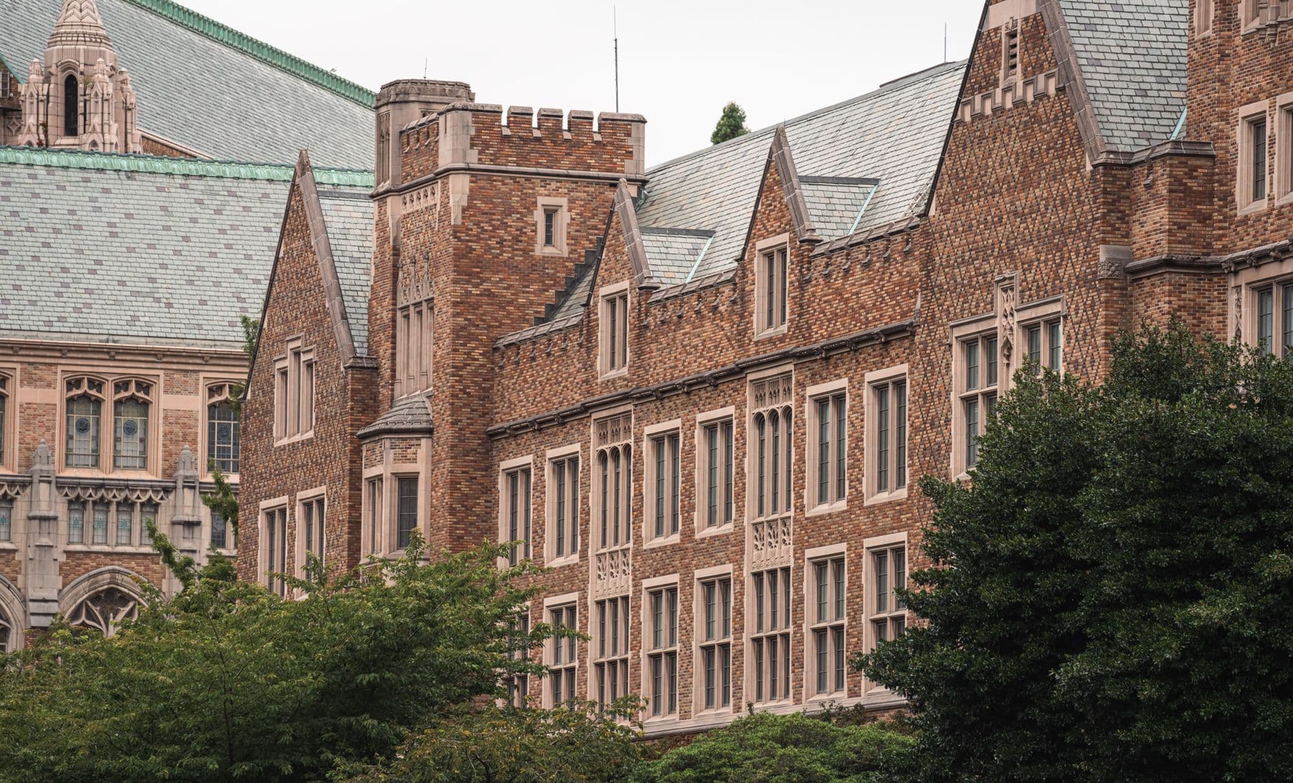 View of historic brick building with slate roofs and Gothic architectural features.